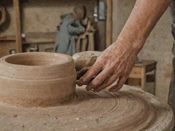 Ceramic artist shaping clay on pottery wheel
